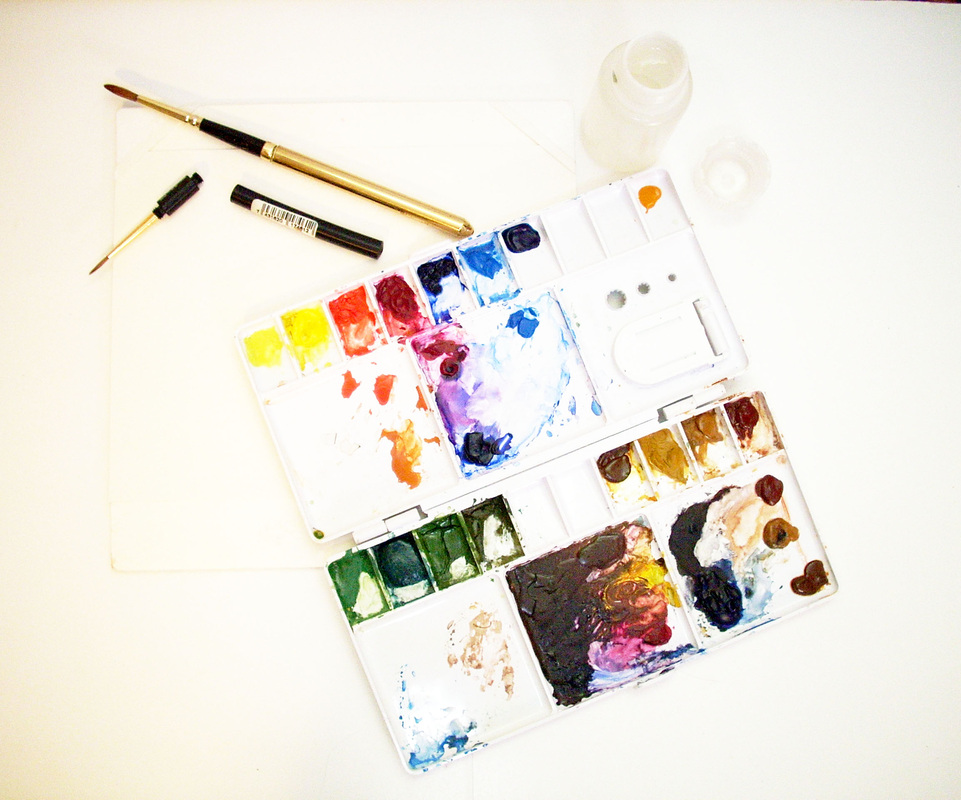 Watercolor field sketching palette, two paint brushes, and small water bottle