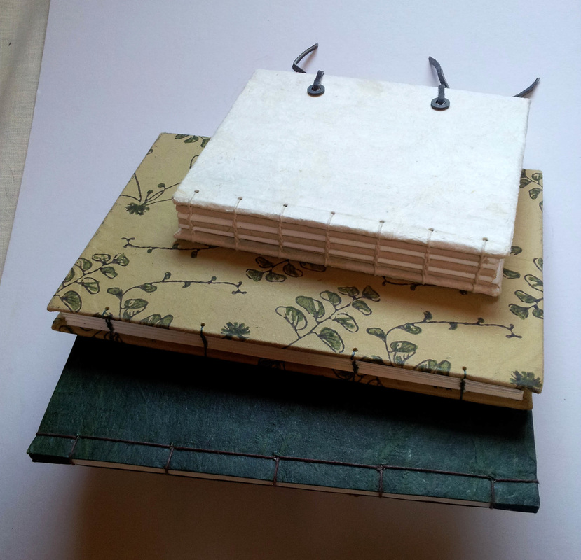 Three hand-made books with watercolor paper.